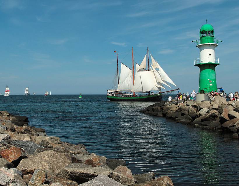 Leuchtturm in Warnemünde mit einem Segelschiff 